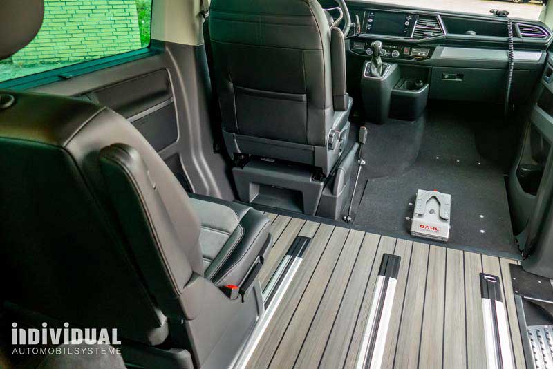 Innenansicht eines Fahrzeuges ohne Beifahrersitz. An der Stelle des Beifahrersitzes ist eine Dockingstation am Fahrzeugboden.