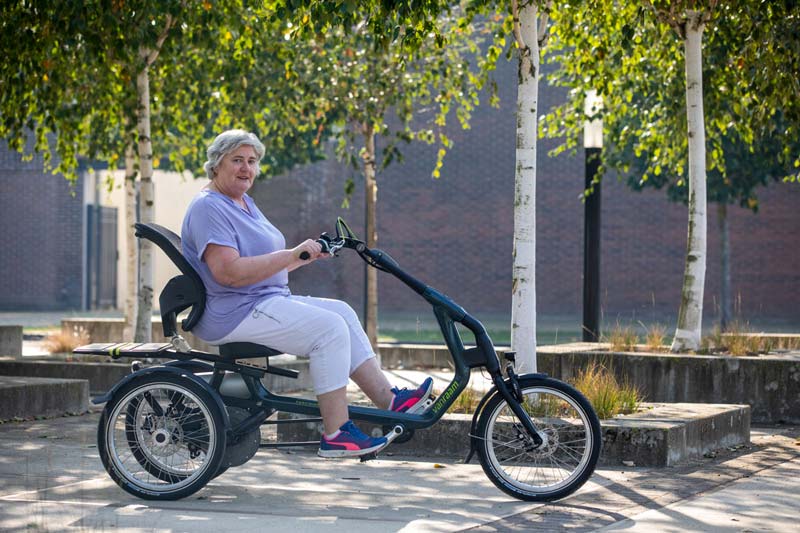 Frau sitzt auf einem E-Dreirad für Erwachsene